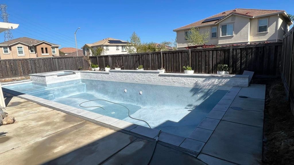 pool being filled with water after fresh resurfacing, new surface visible